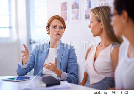 Planning the perfect project. A businesswoman explaining an idea to two female colleagues. Planning the perfect project. A businesswoman explaining an idea to two female colleagues. 90516889