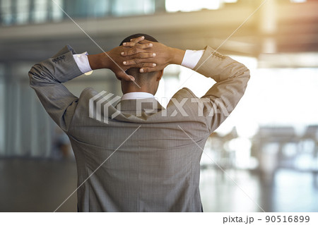 Business comes with its own unique pressure. Rearview shot of a businessman standing with his hands behind his head. 90516899