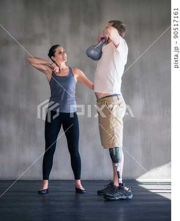 Devoted to my patients health. Shot of a female physiotherapist having a session with a young male amputee. Devoted to my patients health. Shot of a female physiotherapist having a session with a young male amputee. 90517161