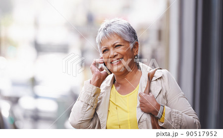 Out and about. Shot of a mature woman talking on her cellphone in the city. 90517952