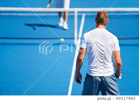 Showing up to every tennis practice. Shot of two people playing tennis outside. Showing up to every tennis practice. Shot of two people playing tennis outside. 90517992