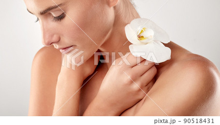 Perfection in the flesh. Closeup studio shot of a beautiful young woman holding an orchid. Perfection in the flesh. Closeup studio shot of a beautiful young woman holding an orchid. 90518431