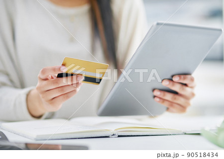 Making a few quick swipes online. Closeup shot of an unrecognisable businesswoman using a digital tablet and credit card in an office. Making a few quick swipes online. Closeup shot of an unrecognisable businesswoman using a digital tablet and credit card in an office. 90518434