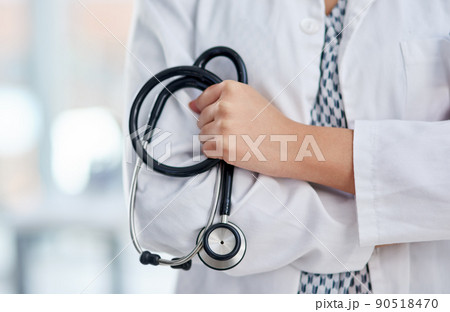 The doctor will see you now. Cropped shot of an unrecognisable doctor holding a stethoscope and crossing her arms. 90518470