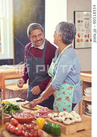 Its a healthy and happy retirement. Shot of a mature couple cooking together at home. Its a healthy and happy retirement. Shot of a mature couple cooking together at home. 90518554