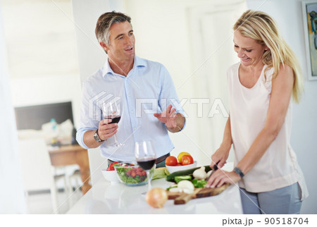 Couples that cook together, stay together. Shot of a mature couple talking together while making dinner. Couples that cook together, stay together. Shot of a mature couple talking together while making dinner. 90518704