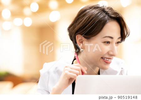 ノートパソコンを使うオフィスカジュアルのミドル女性 90519148