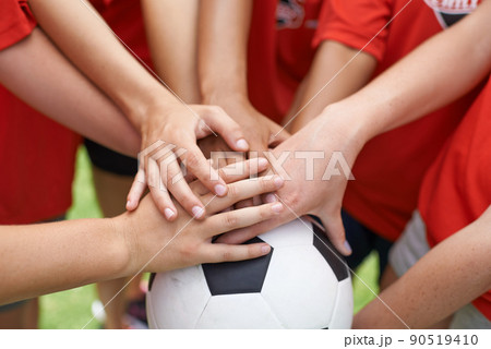 Team spirit. Cropped image of a group of girls with their hands piled on top of a soccer ball. 90519410