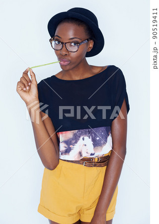 Expressing her childlike side. A young woman posing against white. 90519411