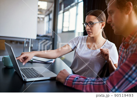 Building their business online platform. Shot of two coworkers having a discussion over a laptop. 90519493