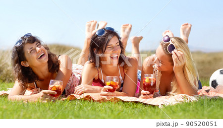 Great girlfriends. A group of friends lying on a blanket outside and enjoying a drink together. Great girlfriends. A group of friends lying on a blanket outside and enjoying a drink together. 90520051