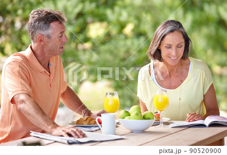 Conversation and companionship. Shot of a mature couple having breakfast together outdoors. Conversation and companionship. Shot of a mature couple having breakfast together outdoors. 90520900