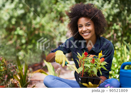 Shes got a green thumb. Portrait of a happy young woman and her tray of plants for the garden. 90521809