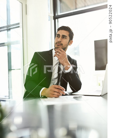 Never lose sight of your goal. Shot of a businessman looking thoughtful while sitting at his desk. Never lose sight of your goal. Shot of a businessman looking thoughtful while sitting at his desk. 90522024