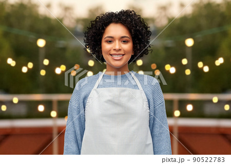 smiling woman in apron over restaurant terrace 90522783