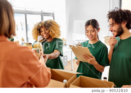 happy volunteers packing food in donation boxes 90522810