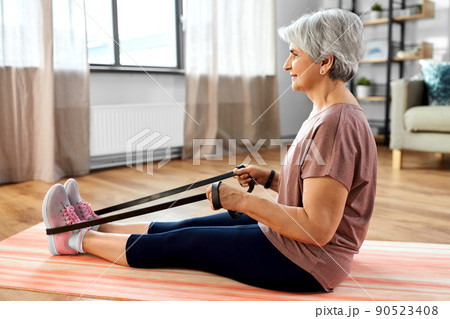senior woman exercising with elastic band at home senior woman exercising with elastic band at home 90523408