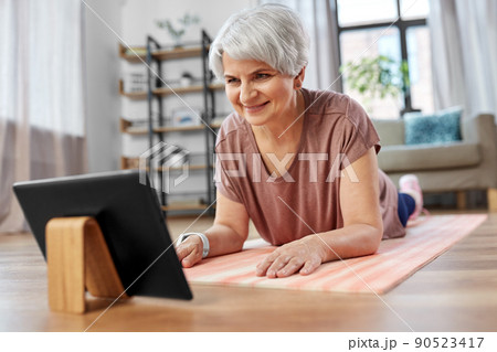 happy woman with tablet pc exercising at home happy woman with tablet pc exercising at home 90523417