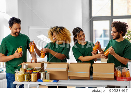 happy volunteers packing food in donation boxes 90523467