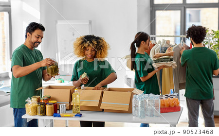 happy volunteers packing food and clothes in boxes 90523468