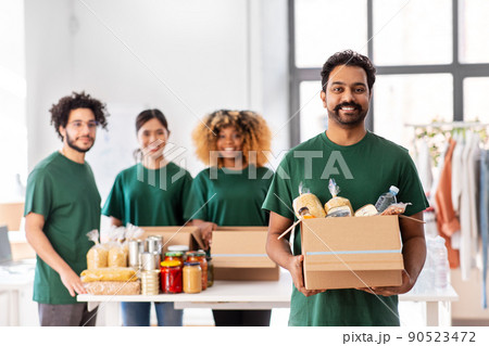happy volunteers packing food in donation boxes 90523472