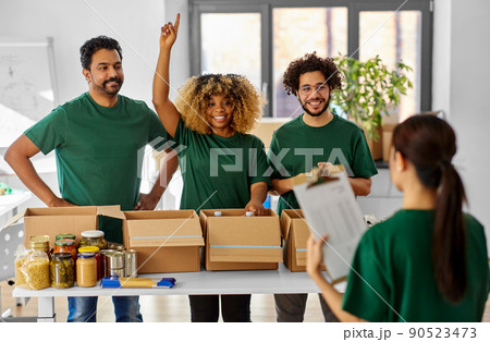 happy volunteers packing food in donation boxes 90523473
