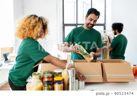 happy volunteers packing food in donation boxes 90523474