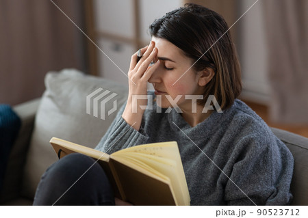 sad woman with diary sitting on sofa at home 90523712
