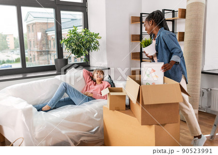 woman unpacking boxes and moving to new home woman unpacking boxes and moving to new home 90523991