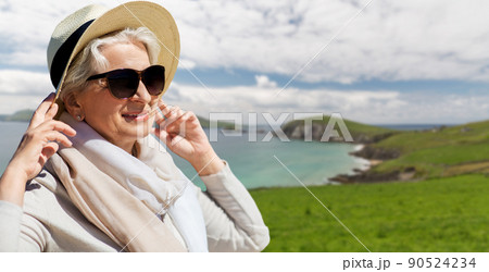 happy senior woman in sunglasses and hat on beach happy senior woman in sunglasses and hat on beach 90524234