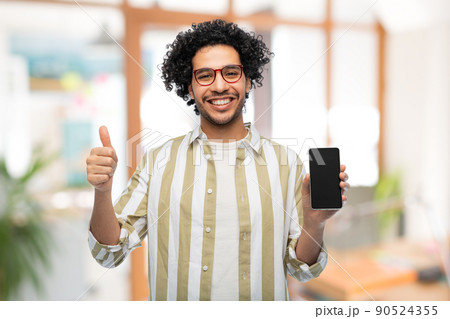man in glasses with smartphone showing thumbs up man in glasses with smartphone showing thumbs up 90524355