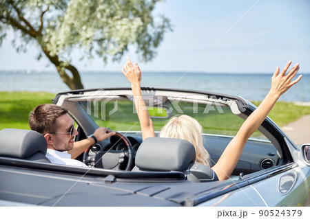 happy couple driving in convertible car happy couple driving in convertible car 90524379