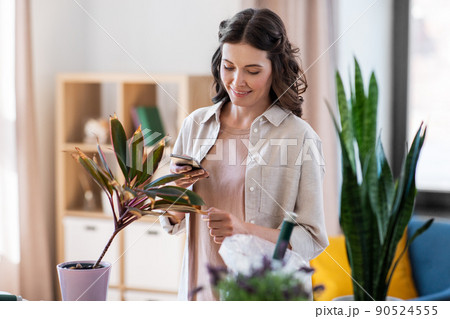 woman with smartphone and pot flower at home woman with smartphone and pot flower at home 90524555