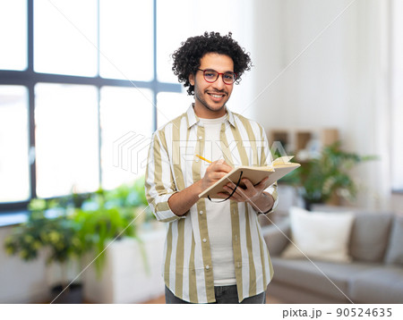 happy smiling man with diary and pencil at home 90524635
