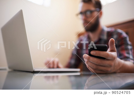 Using all the latest tech. Shot of a handsome young hipster working on a laptop. Using all the latest tech. Shot of a handsome young hipster working on a laptop. 90524705