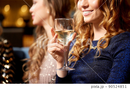 happy smiling woman drinking wine at night club 90524851
