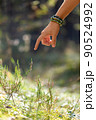 close up of hand with bracelet in forest 90524992
