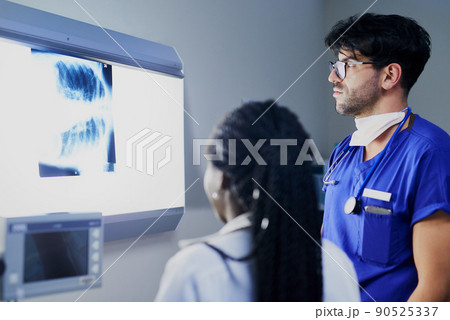Whats happening inside the chest. Shot of a team of surgeons discussing a patients x rays during surgery. Whats happening inside the chest. Shot of a team of surgeons discussing a patients x rays during surgery. 90525337