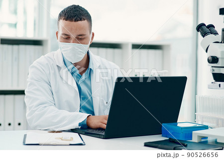 Not your average drug trial. Shot of a young scientist using a laptop while working on a coronavirus cure in a laboratory. Not your average drug trial. Shot of a young scientist using a laptop while working on a coronavirus cure in a laboratory. 90526656