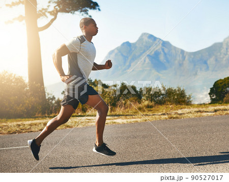 Wind chaser. Shot of a fit young man going for a run outdoors. Wind chaser. Shot of a fit young man going for a run outdoors. 90527017