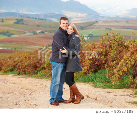 They are in their element. Portrait of a young couple standing together in the vineyards. 90527188