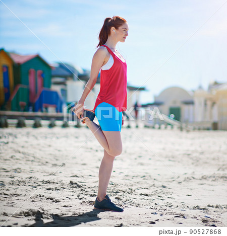 Getting those muscles ready for a workout. Full length shot of a young woman stretching before a work out on the beach. Getting those muscles ready for a workout. Full length shot of a young woman stretching before a work out on the beach. 90527868