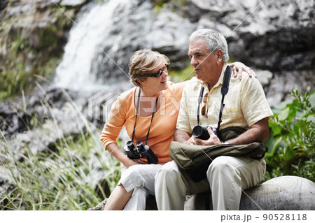 Taking a breather.... A senior couple taking a break while out walking in the forest together. 90528118