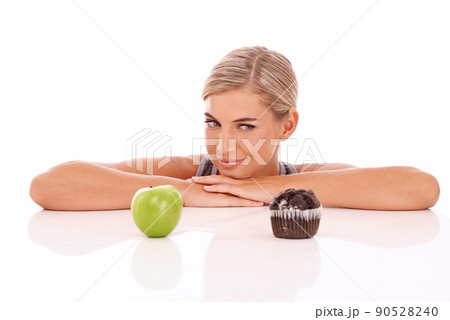 Such a hard choice. A pretty young woman making the choice between a cupcake or an apple. Such a hard choice. A pretty young woman making the choice between a cupcake or an apple. 90528240