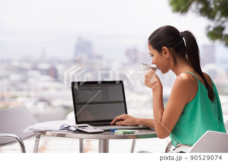 Mornings are grand with a cup of coffee in hand. A young woman working hard while drinking a cup of coffee outdoors. Mornings are grand with a cup of coffee in hand. A young woman working hard while drinking a cup of coffee outdoors. 90529074