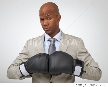 Ready to take on all business competition. Studio shot of an african american businessman wearing boxing gloves. Ready to take on all business competition. Studio shot of an african american businessman wearing boxing gloves. 90529769
