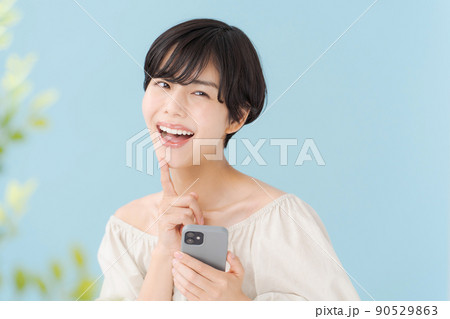 スマホを持つ女性　水色　青 90529863