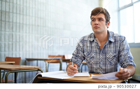 Dedicated to his education. Shot of a young college student studying in class. 90530027