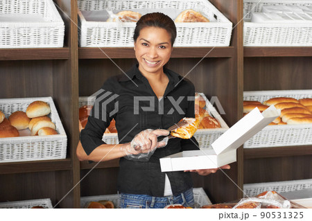 Serving only the freshest to her customers. Portrait of an attractive young woman working in a bakery. Serving only the freshest to her customers. Portrait of an attractive young woman working in a bakery. 90531325
