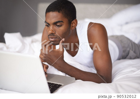 Connected in the morning. Shot of a young man in bed using a laptop. 90532012